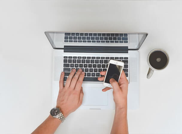 man using laptop while on the phone